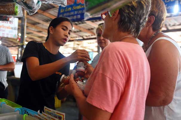 Pui helping to select chilli sauce at the market